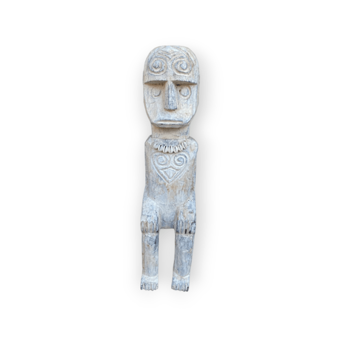 This Timorese Island doll is a beautiful representation of the traditional clothing and adornments worn by the Timorese people. The doll features a brightly colored earring and a "mote" made of colorful beads, which is commonly worn as a skirt or head covering in Timor Island's culture. Hand-carved from wood, this doll is a wonderful example of the craftsmanship and attention to detail that is characteristic of Timorese art. Its intricate design and authentic accessories make it a unique and valuable addition to any collection of cultural artifacts.